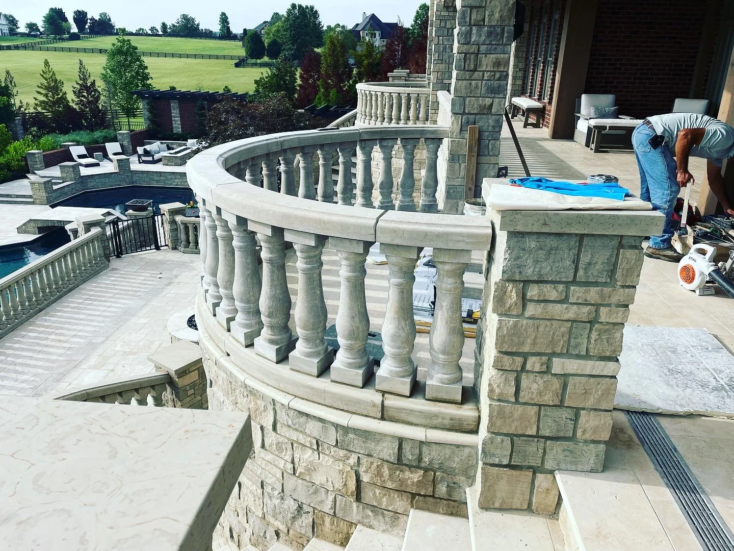 Stone patio with curved balustrade and decorative balusters under construction in Franklin, TN