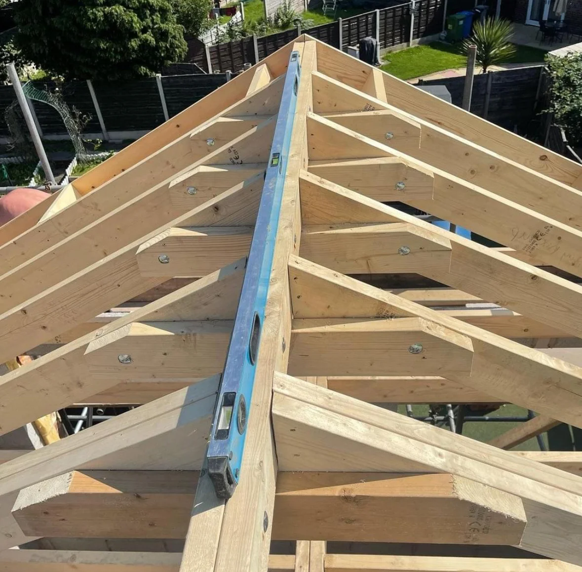 Wooden roof truss framing with engineered joists and ridge beam during construction
