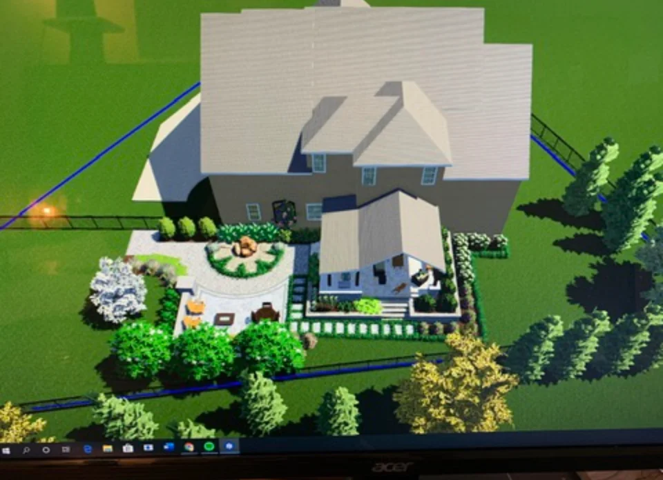 Aerial view of residential landscape design with curved beds, shrubs, and trees around home