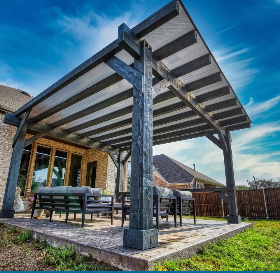 Dark wood pergola with shade panels over concrete patio and outdoor seating area