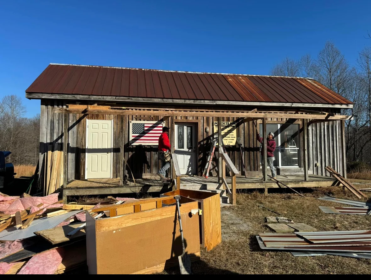 Historic wooden cabin with new metal roof and restored front porch in Franklin, TN